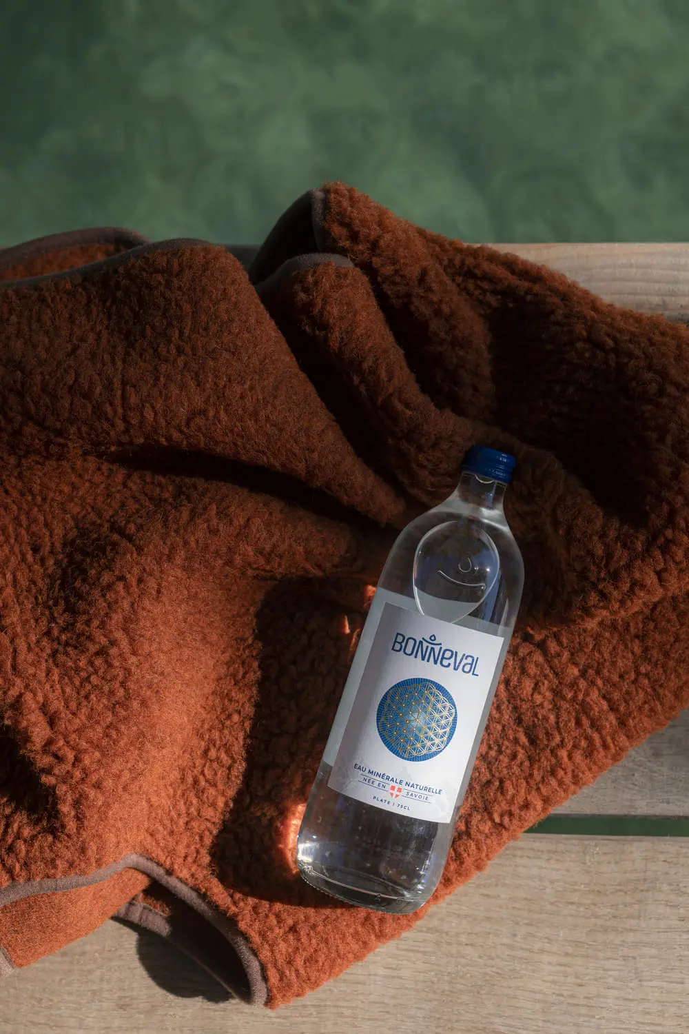 Visuel d'une bouteille d'eau minéral Bonneval posé au bord de l'eau