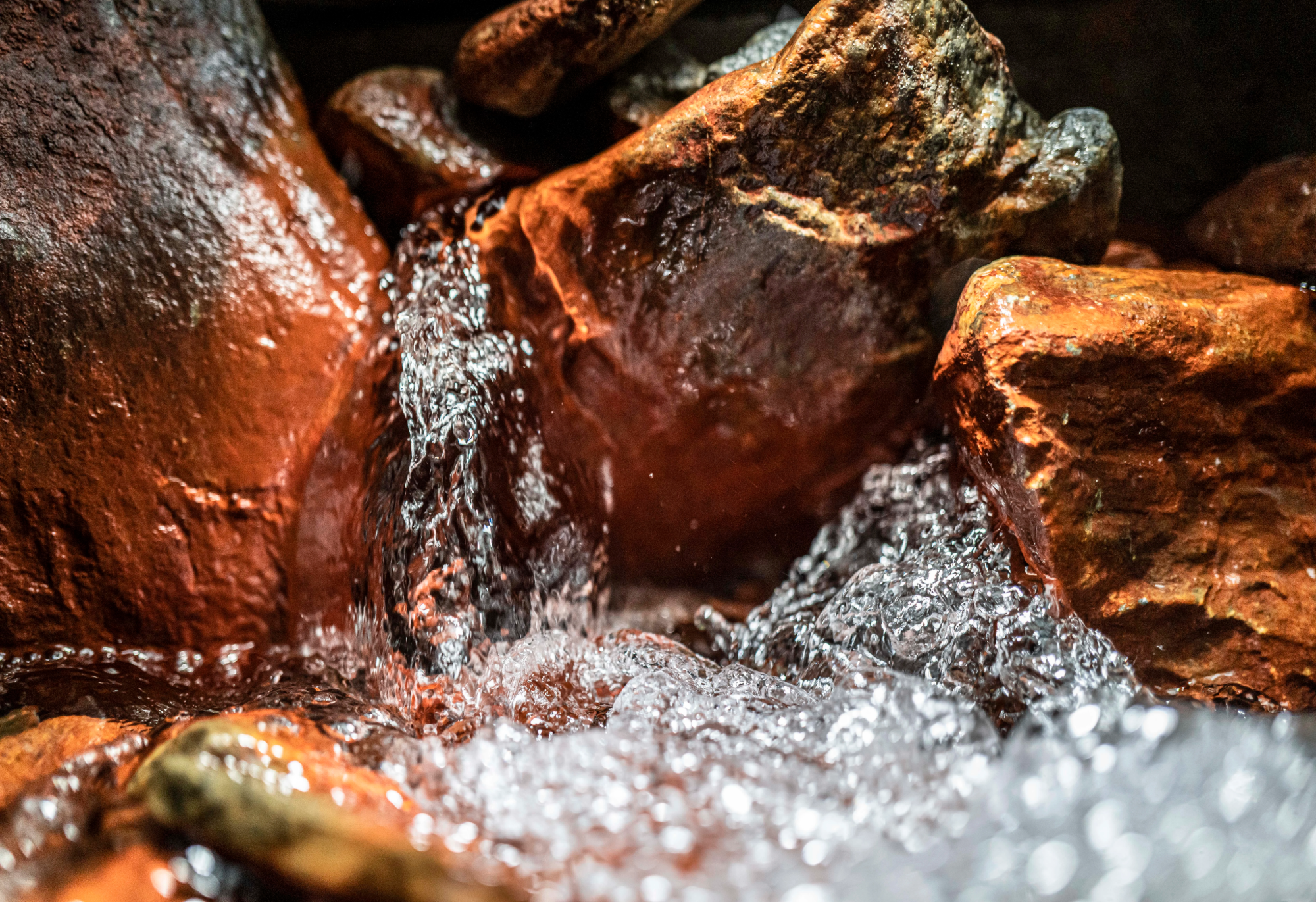 Eau de source pure jaillissant entre les roches naturelles dans les Alpes, captée pour l’eau minérale Bonneval